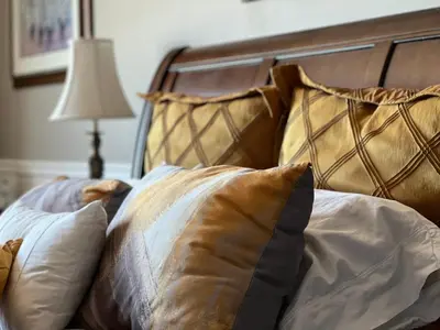a bed with two pillows on it with a lamp at Gîte du Caméléon in Sherbrooke