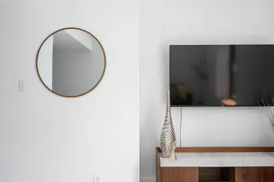 a mirror on a wall next to a tv at Le Nomade MTL in Montréal