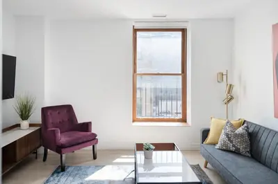 a living room with a couch and a chair at Le Nomade MTL in Montréal
