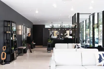 a living room with white furniture and a woman in the background at Griffintown Hôtel in Montréal