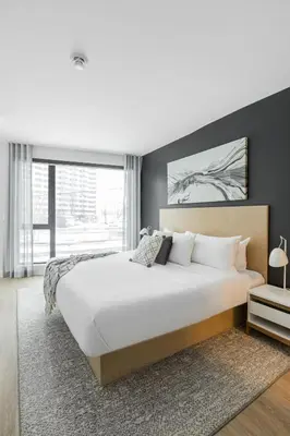 a bedroom with a large bed and a large window at Griffintown Hôtel in Montréal