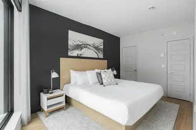 a bedroom with a white bed and a black wall at Griffintown Hôtel in Montréal