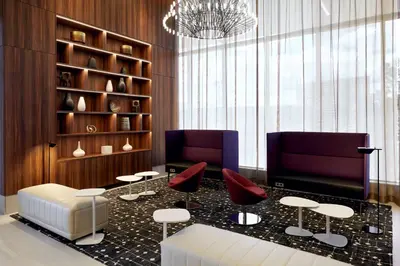 a lobby with two chairs and a table with red chairs at Hilton Garden Inn Montreal Midtown, Quebec, Canada in Montréal