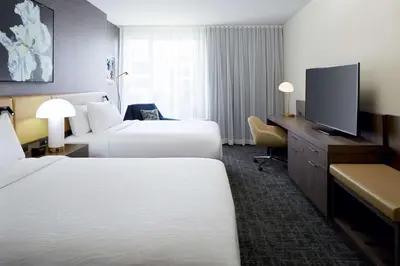 a hotel room with two beds and a flat screen tv at Hilton Garden Inn Montreal Midtown, Quebec, Canada in Montréal