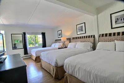 a hotel room with two beds and a table at Motel de la montagne Orford in Orford