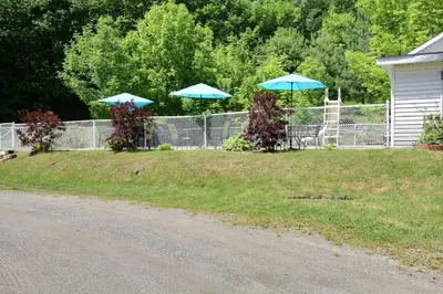 two blue umbrellas in a yard next to a fence at Motel de la montagne Orford in Orford