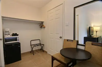 a living room with a table and a small kitchen at Motel de la montagne Orford in Orford