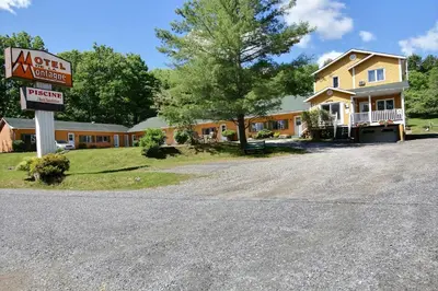 a house with a sign in front of it at Motel de la montagne Orford in Orford