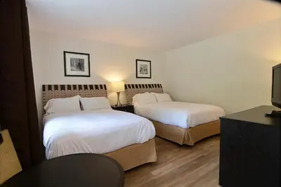 a hotel room with two beds and a television at Motel de la montagne Orford in Orford