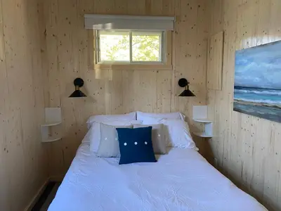 a bedroom with a bed with a blue pillow on it at Chalets Memphrémagog in Magog-Orford