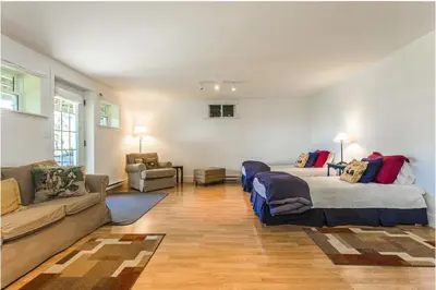 a living room with two beds and a couch at North House - Lovely Lac-Brome 3 Bedroom Lakefront Cottage in Lac-Brome
