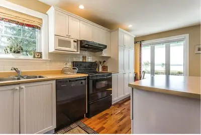 a kitchen with a black stove and a sink at North House - Lovely Lac-Brome 3 Bedroom Lakefront Cottage in Lac-Brome