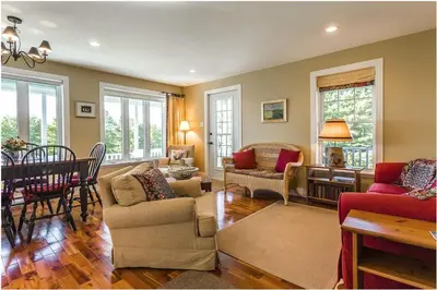 a living room filled with furniture and a dining room at North House - Lovely Lac-Brome 3 Bedroom Lakefront Cottage in Lac-Brome
