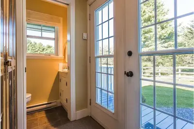 a bathroom with a toilet and large windows at North House - Lovely Lac-Brome 3 Bedroom Lakefront Cottage in Lac-Brome