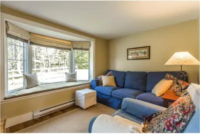 a living room with a blue couch and a window at North House - Lovely Lac-Brome 3 Bedroom Lakefront Cottage in Lac-Brome