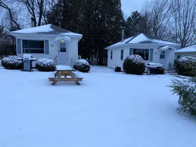 a picnic table in the snow in front of a house at Chalet memphrémagog - 203 in Magog-Orford