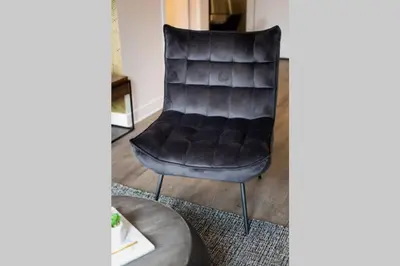 a leather chair in a living room with a rug at Live Like a Local in this Superb Loft by Den Stays in Montréal