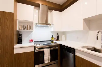 a white kitchen with a stove and a sink at Live Like a Local in this Superb Loft by Den Stays in Montréal
