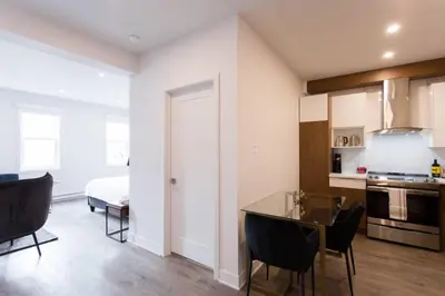 a kitchen and living room with a table and chairs at Live Like a Local in this Superb Loft by Den Stays in Montréal