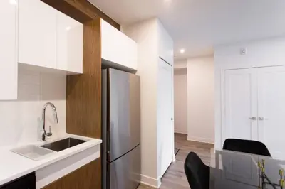 a kitchen with a stainless steel refrigerator and a sink at Live Like a Local in this Superb Loft by Den Stays in Montréal