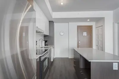 a kitchen with white walls and a large counter top at L'Equinox Modern Apartments by Corporate Stays in Laval