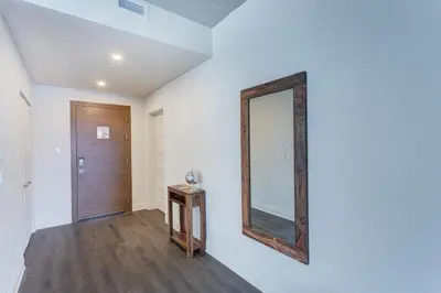 a mirror on a wall next to a door at L'Equinox Modern Apartments by Corporate Stays in Laval