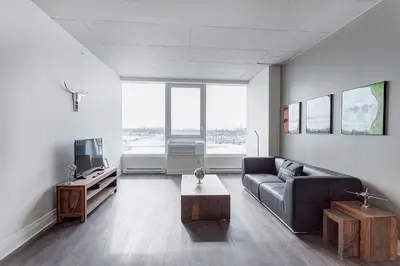 a living room with a couch and a tv at L'Equinox Modern Apartments by Corporate Stays in Laval