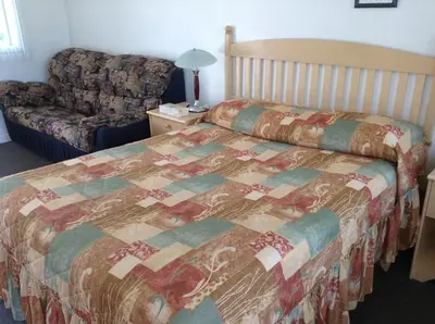 a bedroom with a bed and a couch at Motel St-Thomas in Joliette