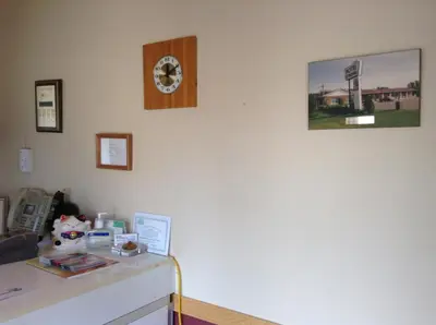 a room with a desk and a clock on the wall at Motel St-Thomas in Joliette