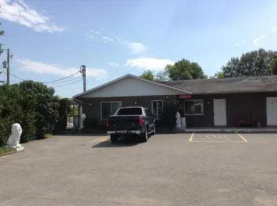 a truck parked in a parking lot in front of a building at Motel St-Thomas in Joliette