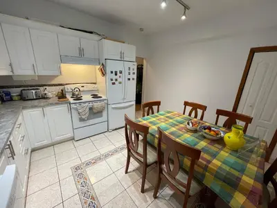 a kitchen with a table with a yellow vase on it at Chambres EL MEDITERRANEO Rooms in Montréal