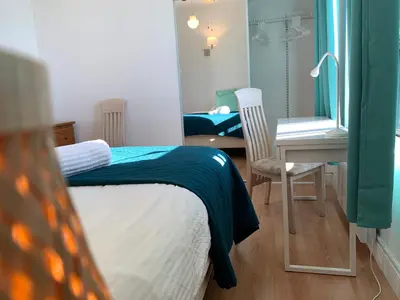 a bedroom with a bed and a desk and a mirror at Chambres EL MEDITERRANEO Rooms in Montréal