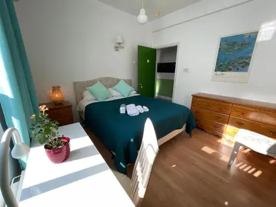 a bedroom with a bed with green sheets and shoes on it at Chambres EL MEDITERRANEO Rooms in Montréal