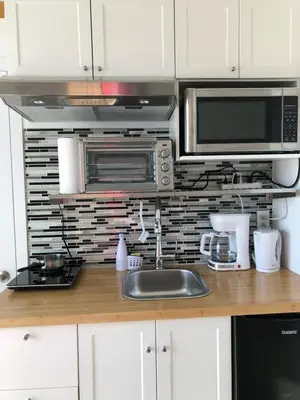 a kitchen with a sink and a microwave at Well Equipped Studio FOR NON-SMOKING GUESTS ONLY CITQ ЗO9467 in Longueuil