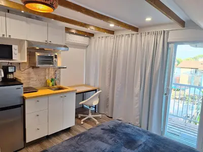 a kitchen with a table and a desk and a window at Well Equipped Studio FOR NON-SMOKING GUESTS ONLY CITQ ЗO9467 in Longueuil