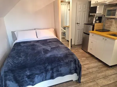 a bed in a small room with a kitchen at Well Equipped Studio FOR NON-SMOKING GUESTS ONLY CITQ ЗO9467 in Longueuil
