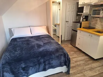 a small bedroom with a bed and a kitchen at Well Equipped Studio FOR NON-SMOKING GUESTS ONLY CITQ ЗO9467 in Longueuil