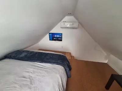 a bedroom with a bed and a tv on the wall at Well Equipped Studio FOR NON-SMOKING GUESTS ONLY CITQ ЗO9467 in Longueuil