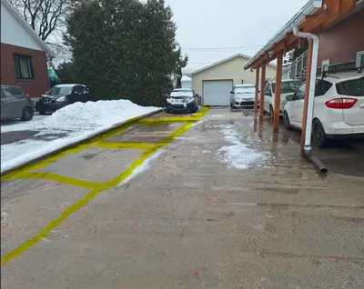 a snow covered driveway with cars parked in a garage at Well Equipped Studio FOR NON-SMOKING GUESTS ONLY CITQ ЗO9467 in Longueuil