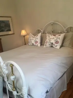 a bedroom with a white bed with pillows at La Belle aux Berges in Saint-Denis-sur-Richelieu