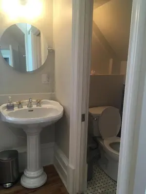 a bathroom with a sink and a toilet and a mirror at La Belle aux Berges in Saint-Denis-sur-Richelieu