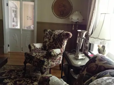 a living room with a chair and a lamp at La Belle aux Berges in Saint-Denis-sur-Richelieu