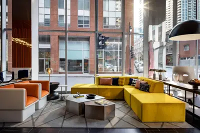 a living room with a yellow couch and a table at Humaniti Hotel Montreal, Autograph Collection in Montréal