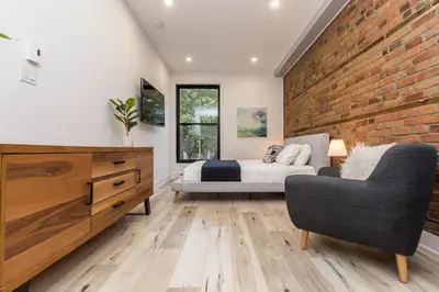 a bedroom with a bed and a brick wall at Lofts du Parc LaHaie in Montréal