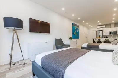 a bedroom with two beds and a flat screen tv at Lofts du Parc LaHaie in Montréal