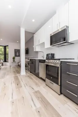 an open kitchen with stainless steel appliances and wooden floors at Lofts du Parc LaHaie in Montréal