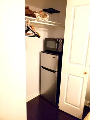 a small kitchen with a microwave and a refrigerator at Maison Montplaisir in Montréal