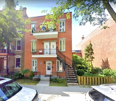 a brick building with a staircase in front of it at Maison Montplaisir in Montréal