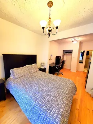 a bedroom with a bed with a blue comforter at Maison Montplaisir in Montréal