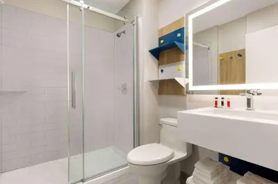 a bathroom with a shower and a toilet and a sink at Microtel Inn Suites by Wyndham Lac-Megantic in Lac-Mégantic